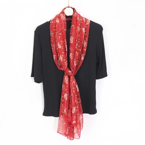 Close-up of red floral georgette scarf knotted over black ribbed summer shirt top