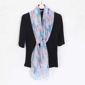 Close-up of lightweight chiffon beach scarf with vibrant pink and blue leaf pattern