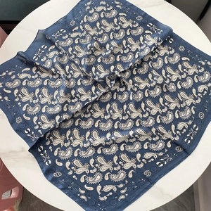 Carré de soie bleu marine vintage avec motif paisley pour femme sur table en marbre
