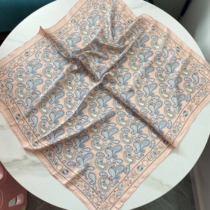 Carré de soie vintage à motif paisley rose et bleu sur un fond en marbre élégant
