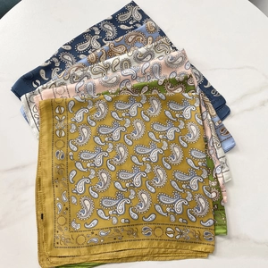 Mise à plat de plusieurs foulards carrés en satin aux motifs paisley de couleurs variées