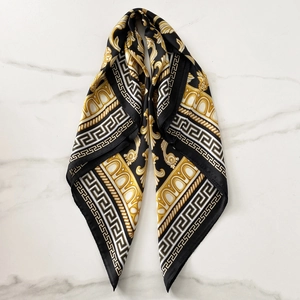 Detail view of baroque pattern silk scarf with Greek key borders on marble texture