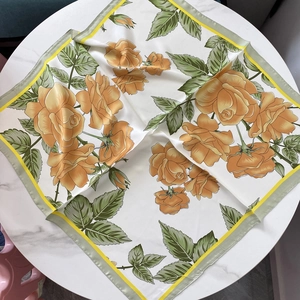 Breathable imitation silk square scarf with orange floral rose print on marble table