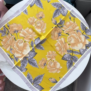 Breathable floral silk scarf with yellow base and orange roses on white table