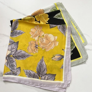 Floral print satin silk square scarves in yellow, black, and grey on marble background