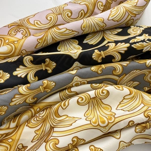 Detail of multi-color satin scarves featuring golden baroque patterns and silky texture
