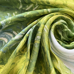 Detail van de satijnen sjaaltextuur met groen en wit abstract patroon en glans