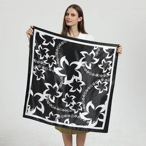 Carré de soie satiné 90x90 noir et blanc à motif floral tenu par un mannequin