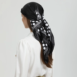 Rear view of a model wearing a black satin headscarf with white polka dots and border