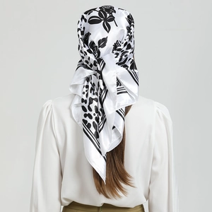 Détail d'un foulard en satin avec motifs de roses et léopard porté par un mannequin