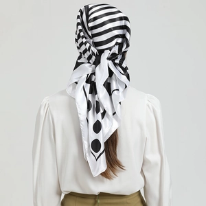 Détail d'un foulard en soie à rayures et pois, noué en bandeau pour un look élégant