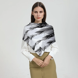 Détail d'un grand foulard en soie synthétique à motifs géométriques noir et blanc chic