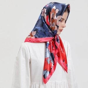 Écharpe en satin bleu marine et rouge avec imprimé floral portée en foulard