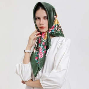 Élégant carré de soie vert foncé avec motif floral porté comme un foulard vintage