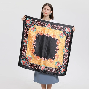 Détail d'un grand foulard carré en soie avec motifs floraux noirs et dorés vintage
