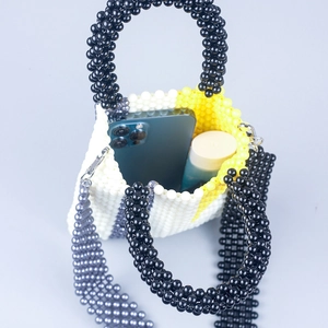 Fashionable geometric beaded crossbody bag showing interior capacity for phone and makeup