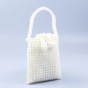 Detail view of handmade pearl beaded handbag with drawstring closure and glossy finish