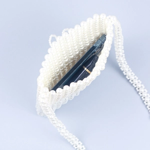 Détail montrant la capacité intérieure du sac à bandoulière en perles avec un smartphone