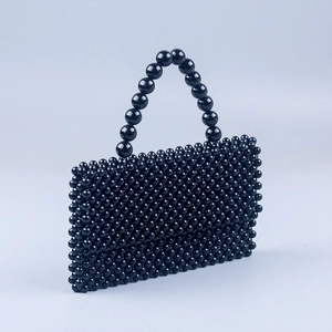 Detail of the high-shine black resin beads and sturdy arched handle of this beaded handbag