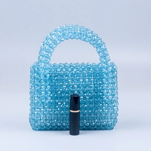 Detailed macro view of light blue beaded mini bag with lipstick for size reference