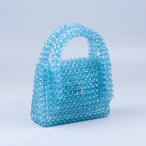 Close-up of handmade blue beaded handbag with faceted acrylic beads and silver twist lock