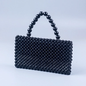 Close-up of polished black beaded texture on a handmade acrylic handbag with a top handle