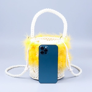 Elegant pearl bucket bag with yellow feathers and woven pearl shoulder strap handle