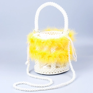 Close-up of bright yellow feather bucket bag with beaded pearl handle and strap