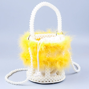 Detail of elegant yellow feather bucket bag with white pearl handle and drawstring pouch