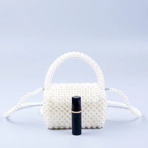 Mini borsa fatta a mano con perle bianche mostrata con rossetto per riferimento taglia