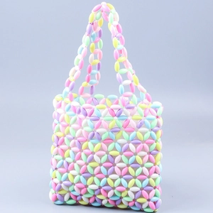 Détail macro des perles d'acrylique macaron tissées et du motif floral sur le sac à main