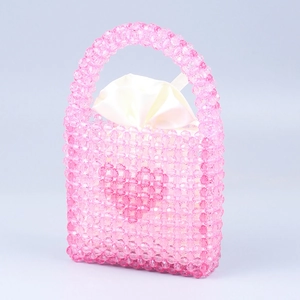 Detail of pink beaded handbag with heart pattern and smooth white satin lining