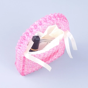 Pink handmade acrylic beaded handbag with white ribbon drawstring and semi-transparent finish