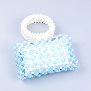 Détail d'un mini sac en perles bleues et blanches aux motifs floraux tissés complexes