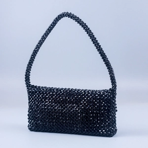 Detail view of the hand-woven black acrylic bead texture on a square crossbody bag