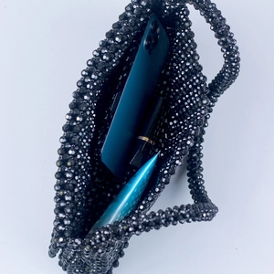 Handmade black acrylic beaded flap handbag showing interior space for phone and makeup
