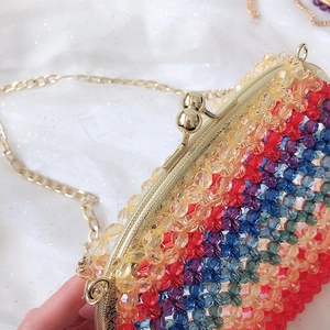 Close-up of rainbow acrylic beaded bag with gold metal frame and double ball clasp