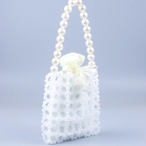 Detail of white beaded handbag with faux pearl handle and white satin drawstring pouch