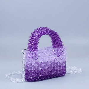 Detail of handmade beaded handbag with purple gradient acrylic beads and handle