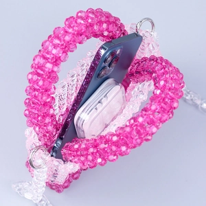 Detail view of woven beaded handbag interior with phone and wireless earphones