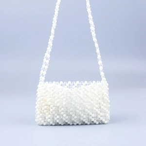 Detail of handmade beaded bag with cream and clear acrylic pearls in a wavy pattern
