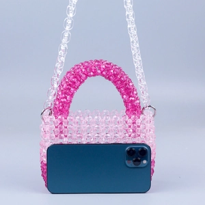 Detail of pink gradient beaded mini bag showing capacity compared to a smartphone