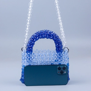 Detailed view of handmade gradient blue acrylic bead weaving and chunky clear chain