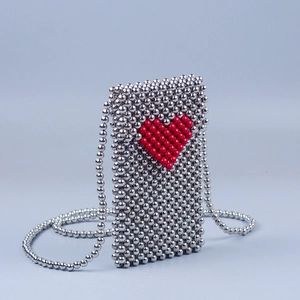 Detailed close-up of handmade silver beaded crossbody bag with a red heart pattern