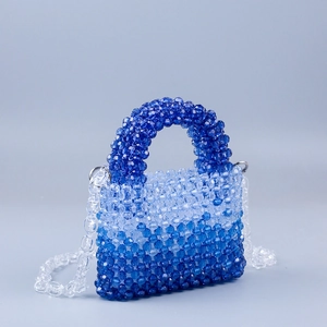 Detail of gradient blue handmade beaded bag showing weaving craft and acrylic beads