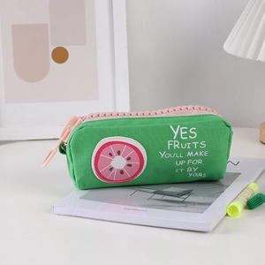 Detail of green canvas pencil case with large pink zipper and fruit embroidery slice