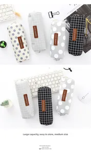 Detalle de varios estuches minimalistas a cuadros con etiquetas de cuero en escritorio