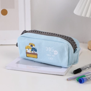 Detail of light blue canvas pencil case featuring large grey zippers and cute shiba inu prints
