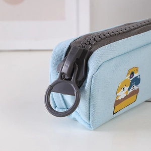 Detail of light blue canvas pencil case featuring a large zipper and cute shiba inu print