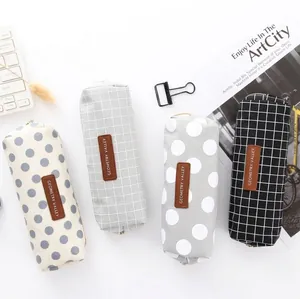 Minimalistische canvas etuis met ruit- en stippenpatronen en bruine leren labels